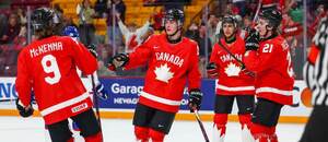 Kanaďania Gavin McKenna (prvý zľava) a Brady Martin (druhý zľava) oslavujú gól proti Slovensku.