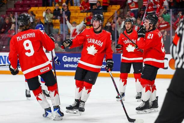 Kanaďania Gavin McKenna (prvý zľava) a&nbsp;Brady Martin (druhý zľava) oslavujú gól proti Slovensku.