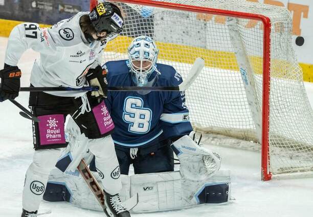 Brankár HC Slovan Bratislava Jaroslav Janus, vľavo útočník HC Košice Simon Jellúš.